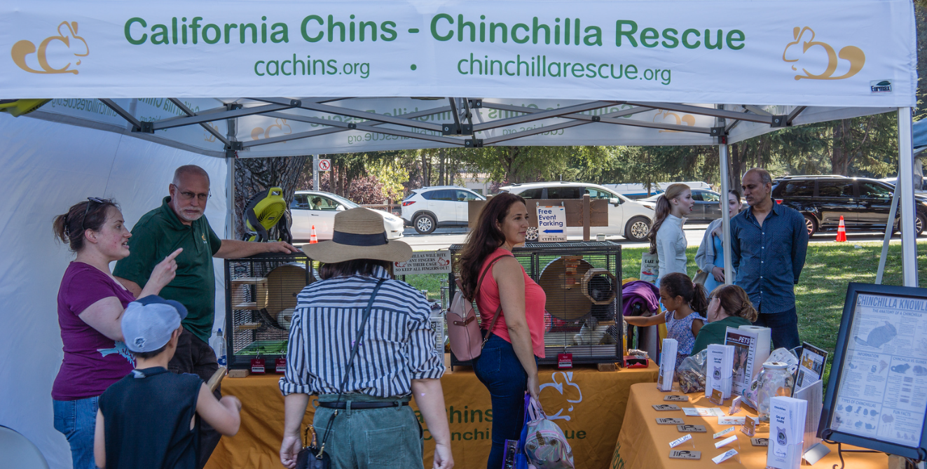 A group of people standing around a shinshin educational foundation booth