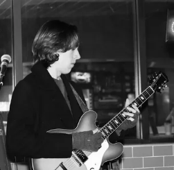 A black and white photo of a man playing a guitar
