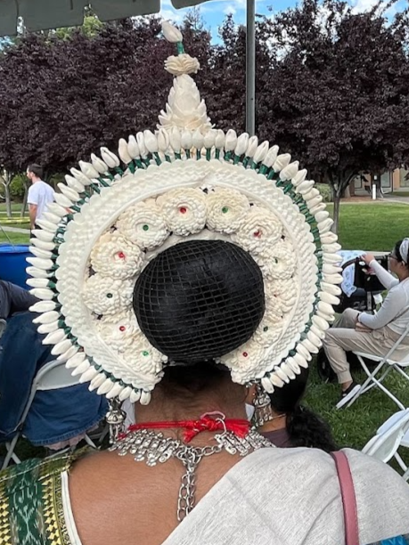 Two women are sitting under a tent with their hair in buns