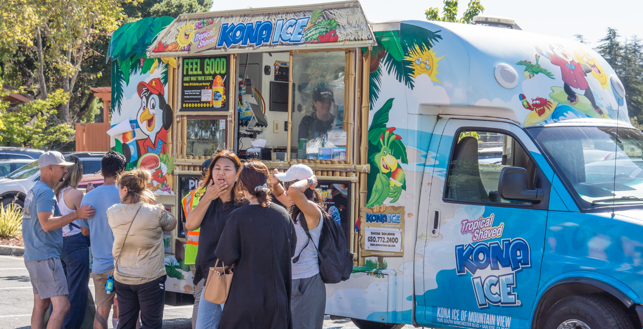 A group of people standing in front of a food truck