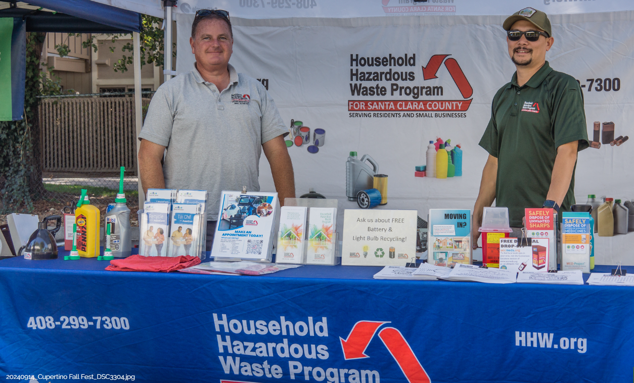 A group of people standing under a tent that says friends of stevens creek trail