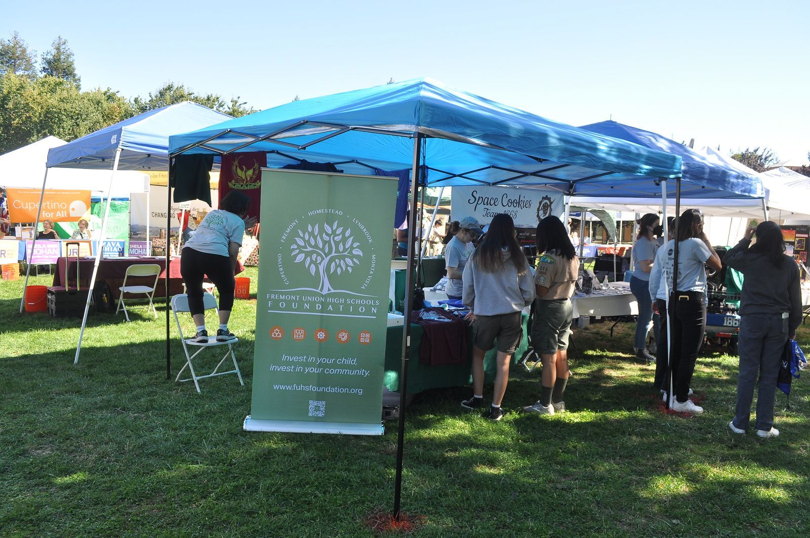 A group of people are standing under a tent at a festival.