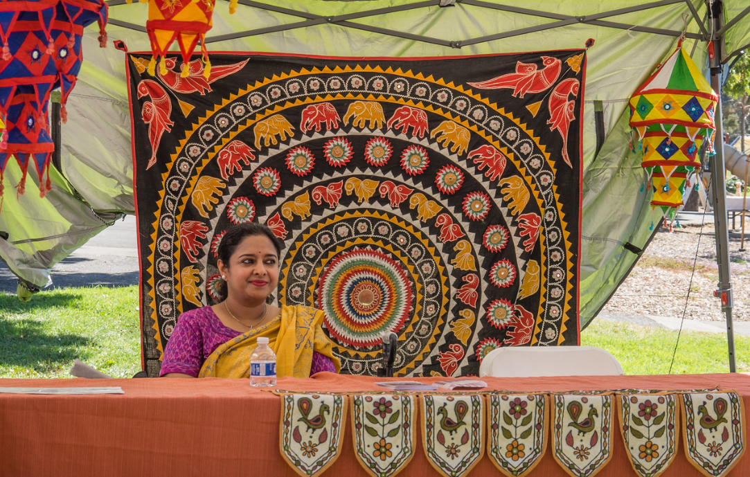 A group of people wearing masks are standing in front of a table.