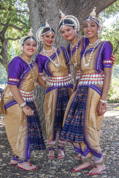 A group of young girls are dancing in a park.
