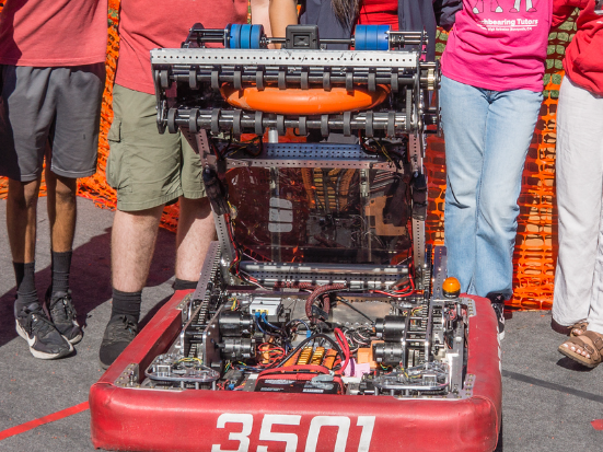 Two people working on a machine that says 1868 on it