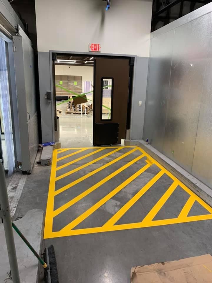 Yellow diagonal stripes marking the floor leading to a doorway marked 
