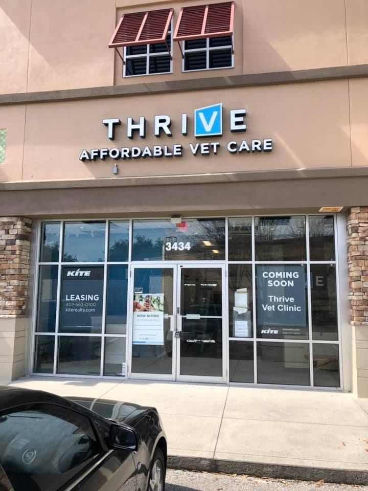 Thrive Affordable Vet Care storefront with glass doors, brown awning, and 