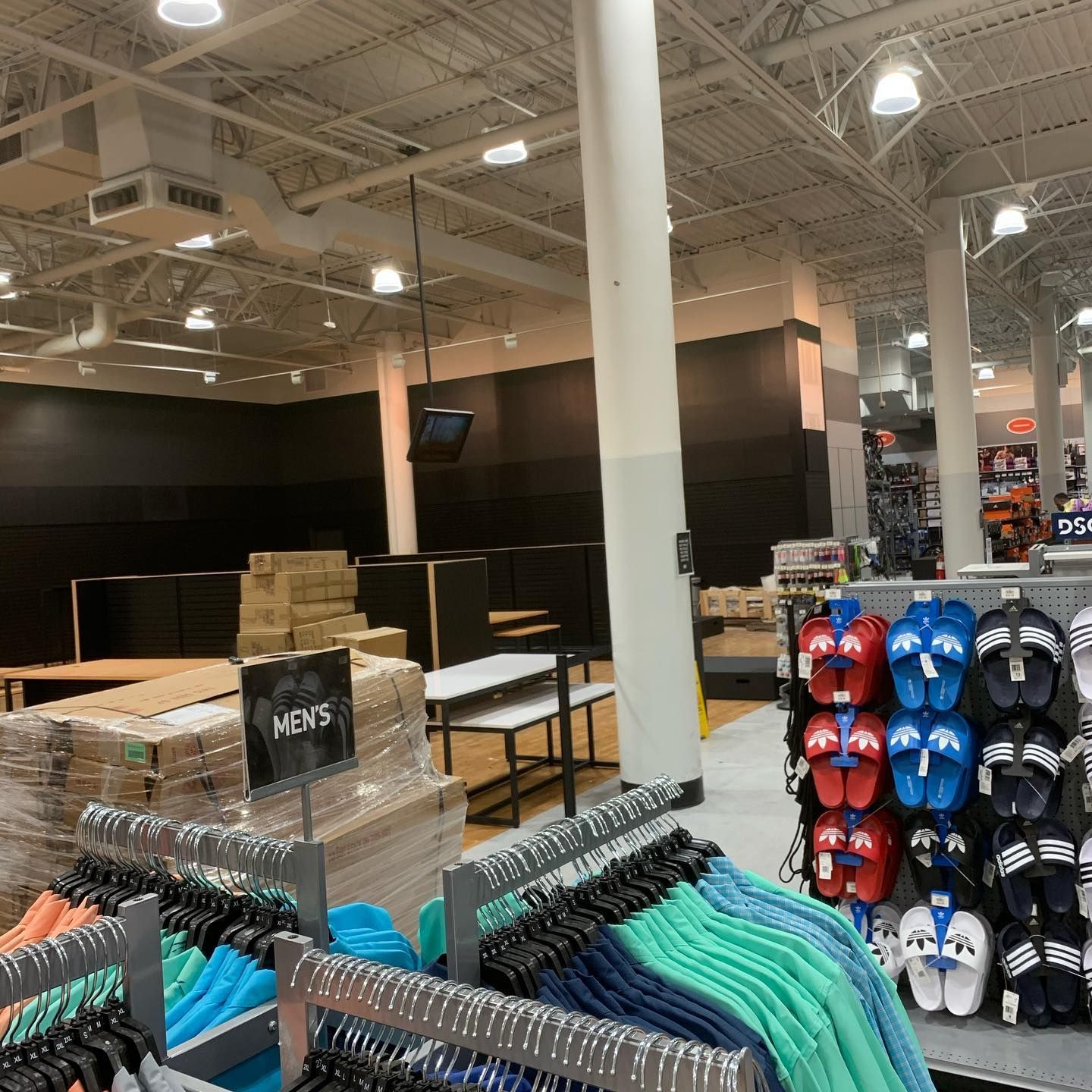 Inside a store with merchandise displays, clothing racks, and various shoe options.