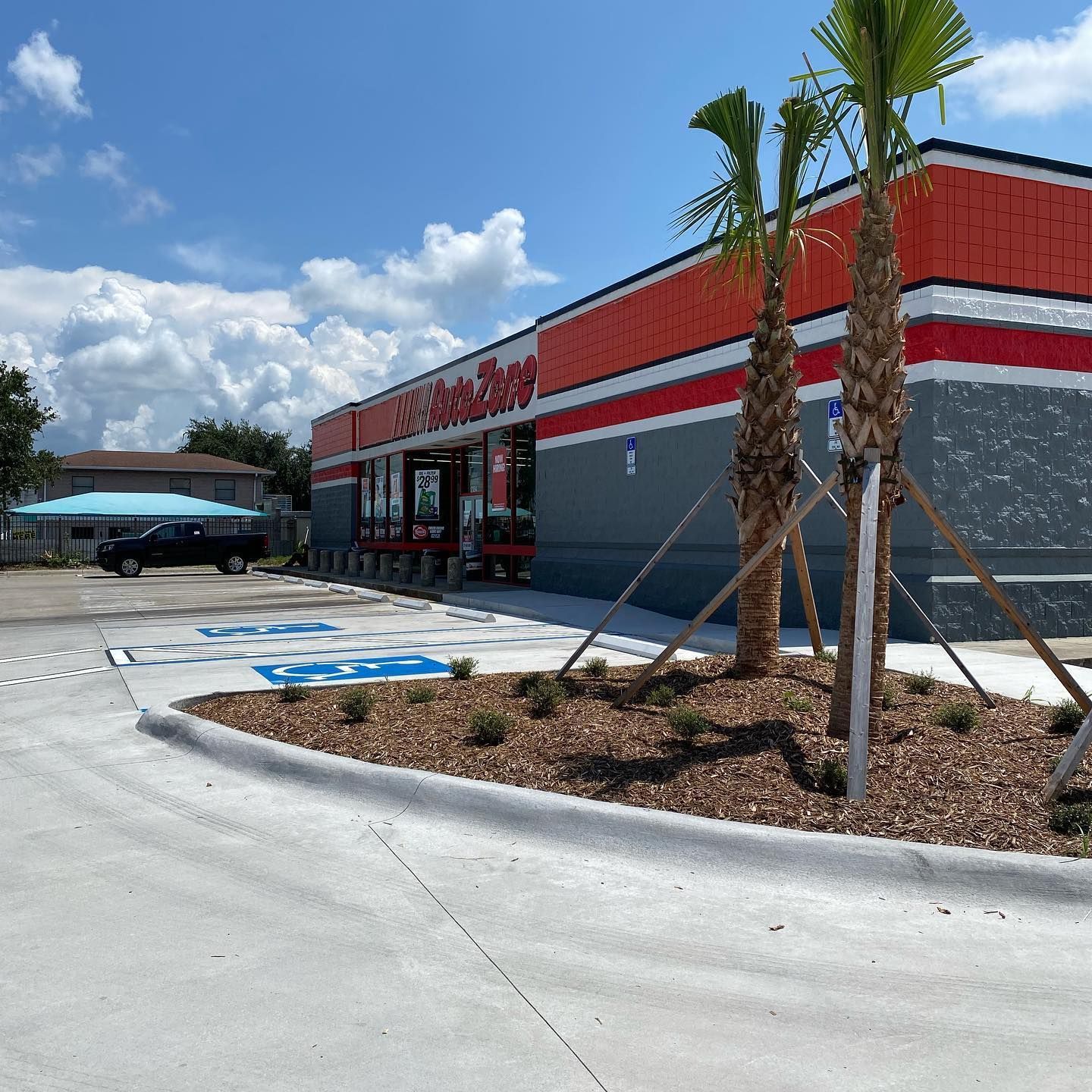Exterior of an AutoZone store on a sunny day; features accessible parking and landscaping.