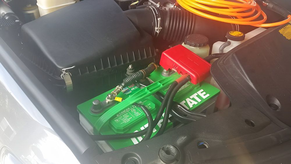A Green Battery Is Sitting Under The Hood Of A Car — Mudgeeraba Auto Electrical & Mechanical In Mudgeeraba, QLD