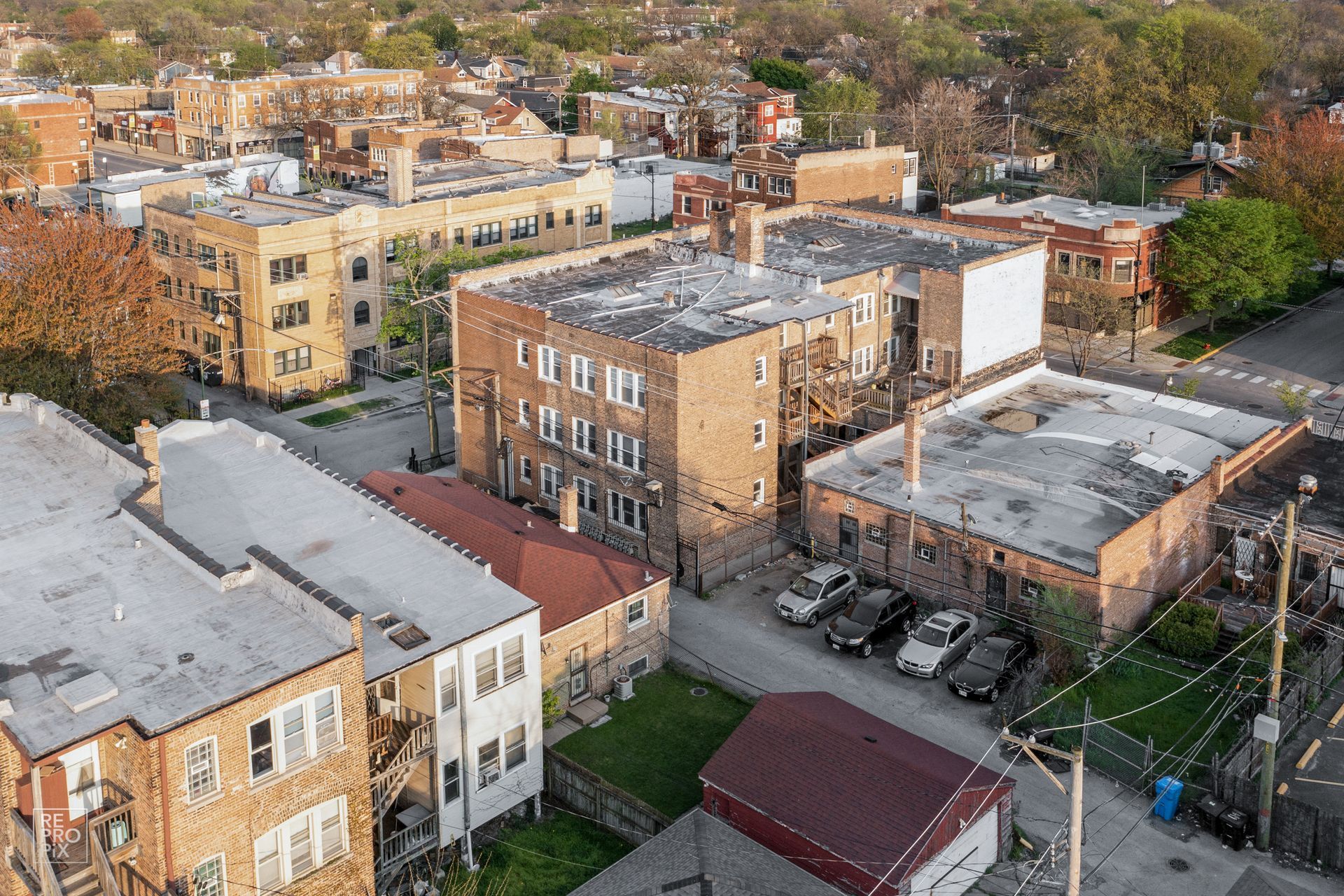 Aerial view of residential buildings with brick facades and flat roofs, in an urban setting.
