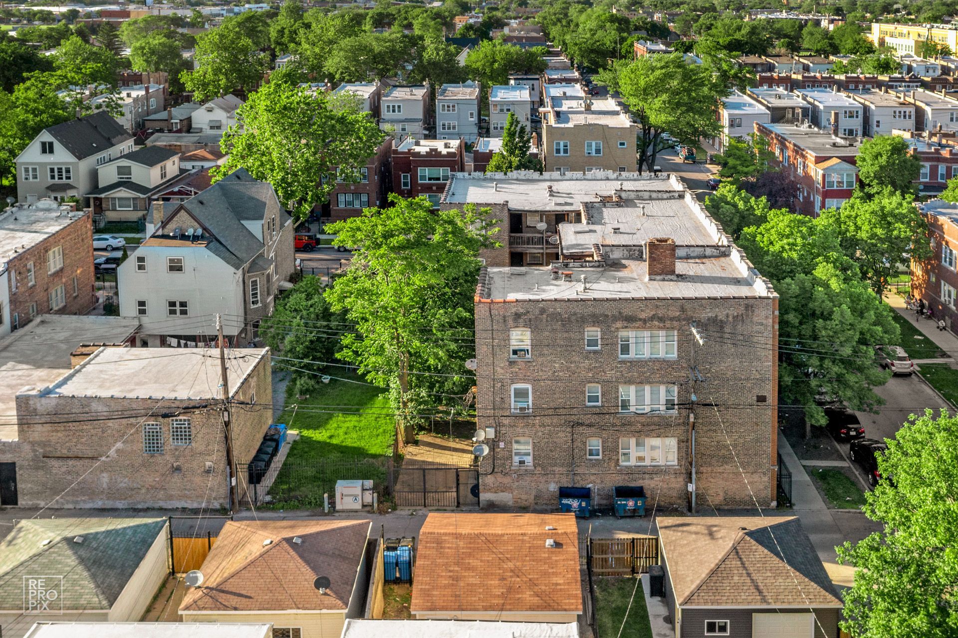 Aerial view of urban neighborhood with brick apartment building and surrounding houses.