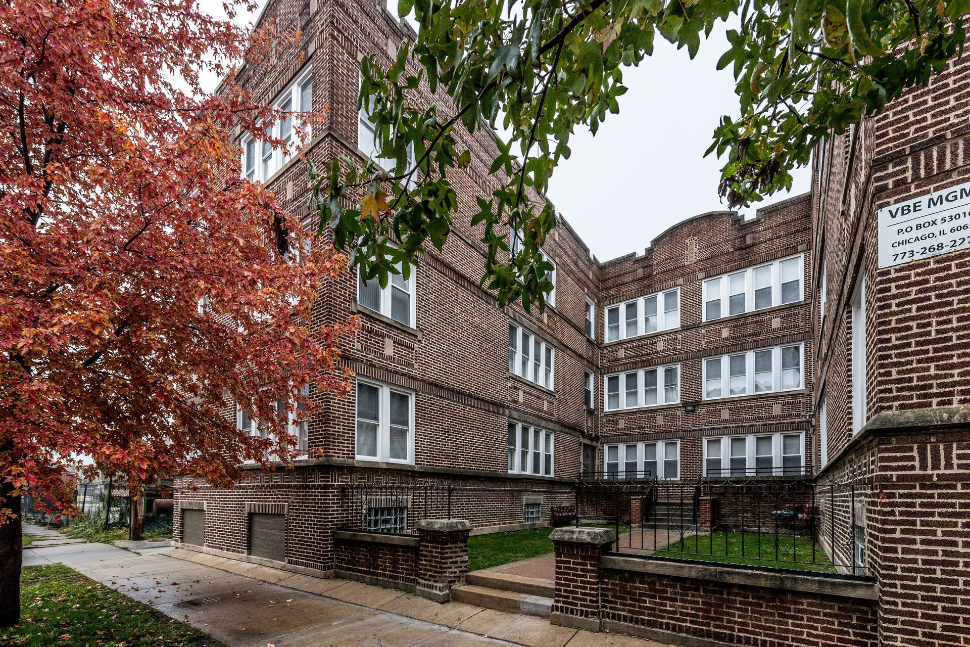 Brick apartment building with autumn trees.