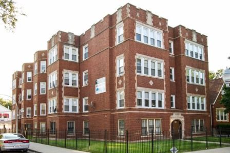 Red brick multi-story apartment building with light trim.
