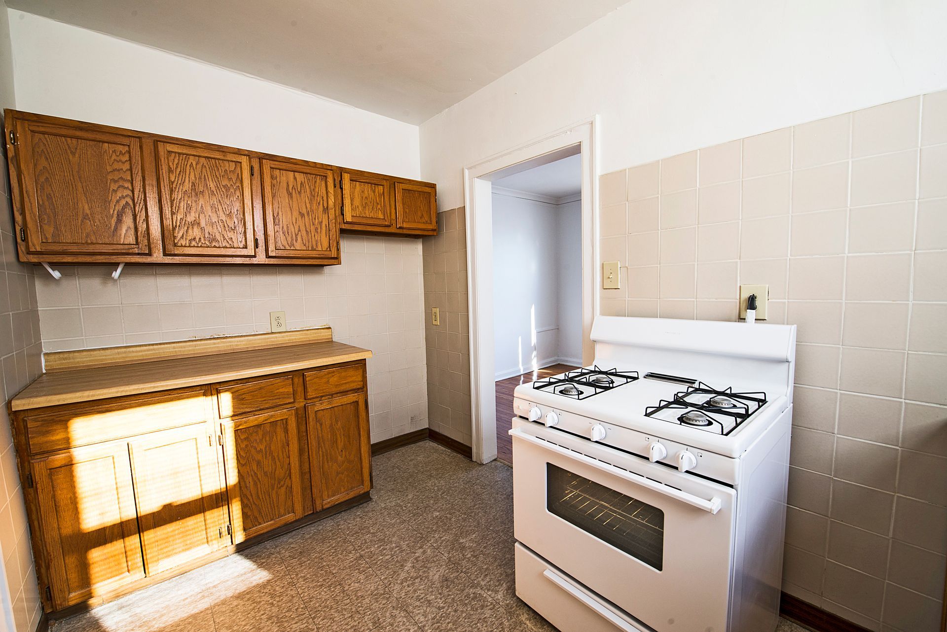 Kitchen with wooden cabinets, white stove, and tile backsplash.