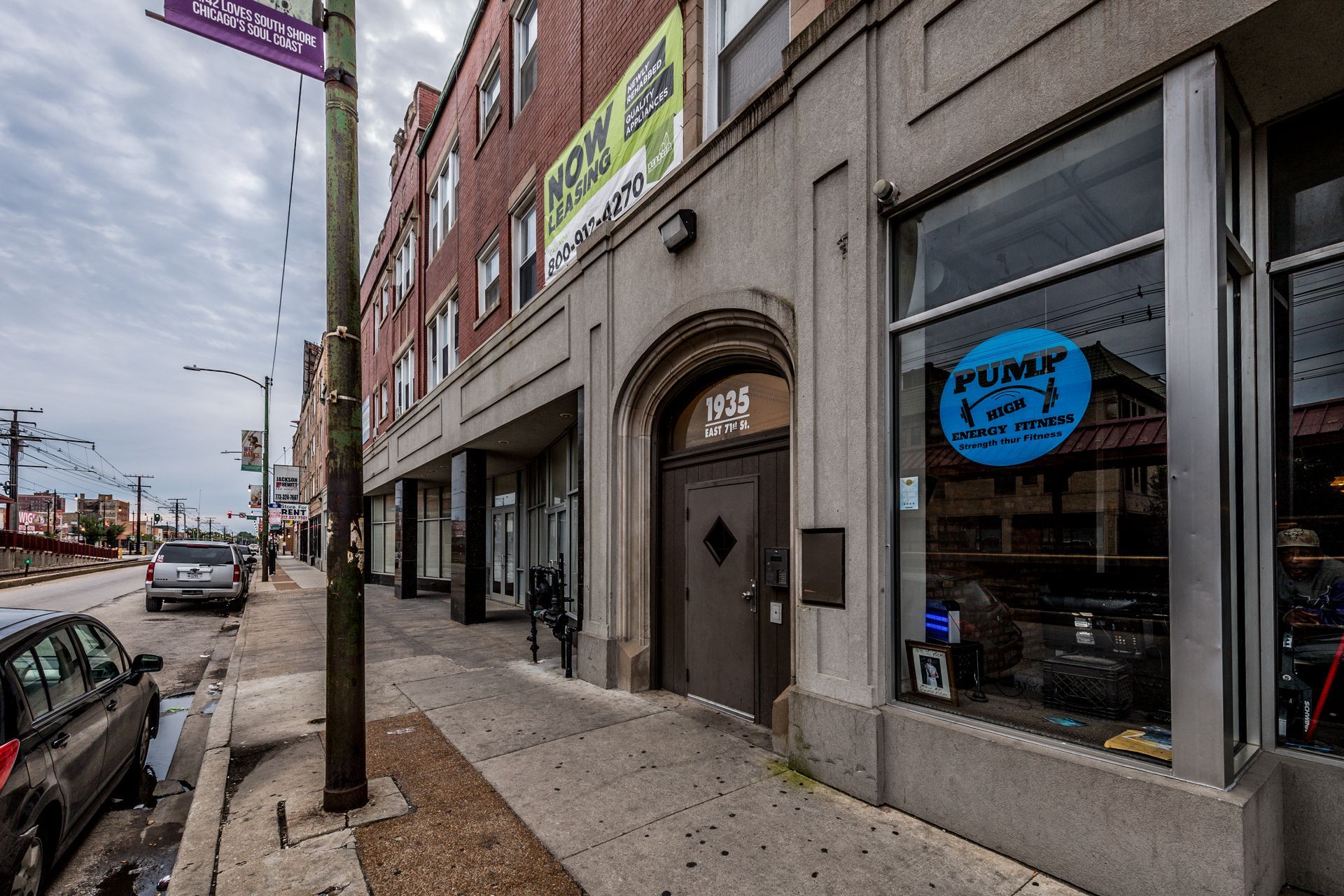 Building facade with arched doorway and business window. 