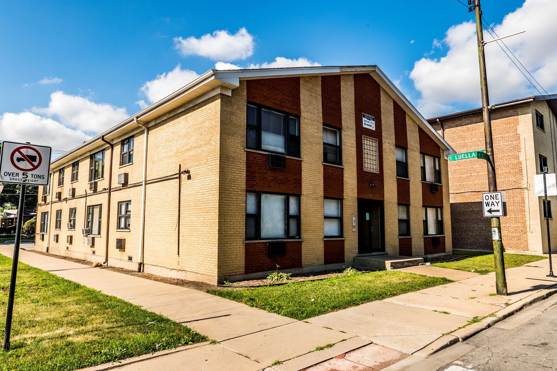 Two-story brick building on a sunny street corner with a no-turn sign.