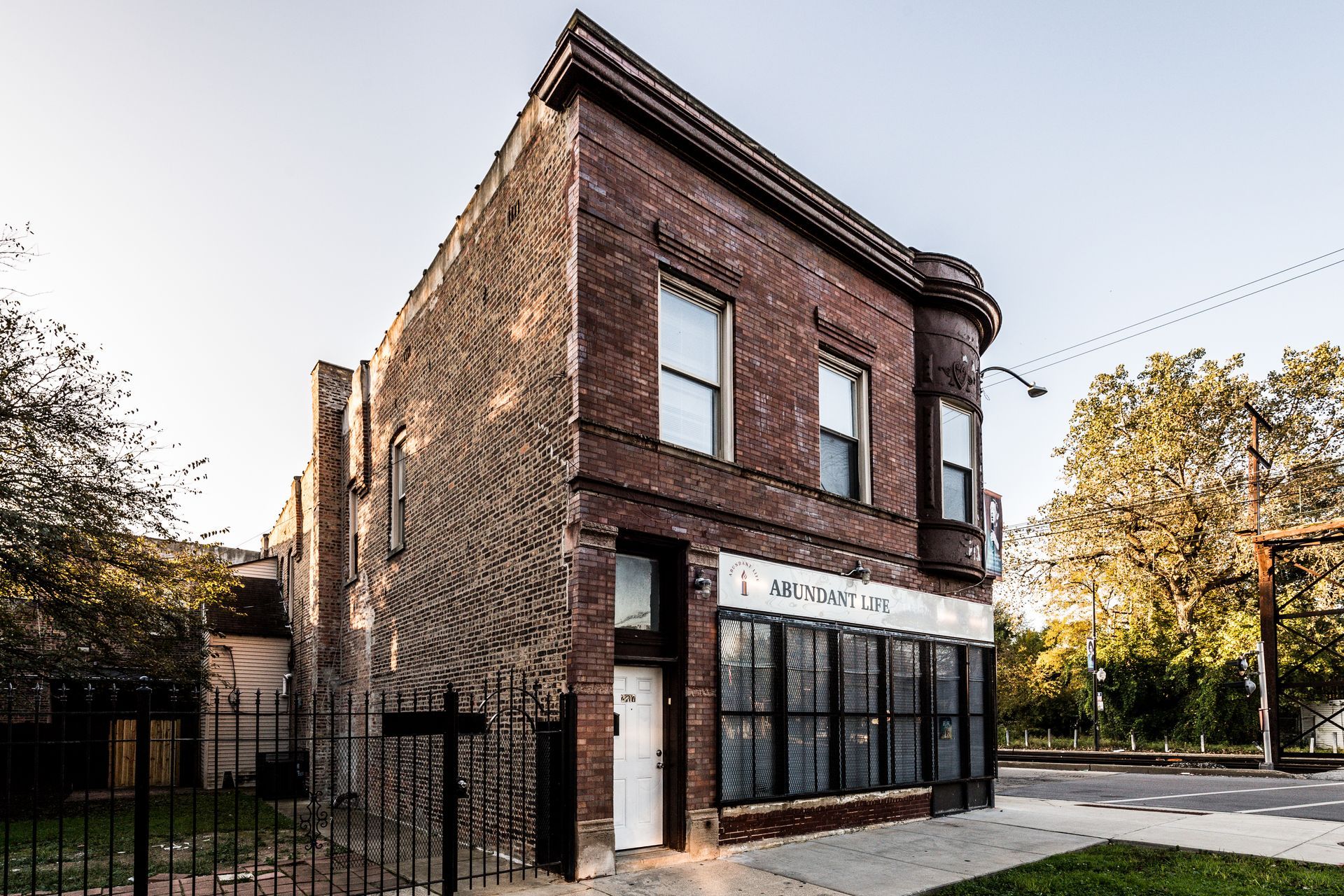 Two-story brick building with large storefront windows; ivy climbs the side. 