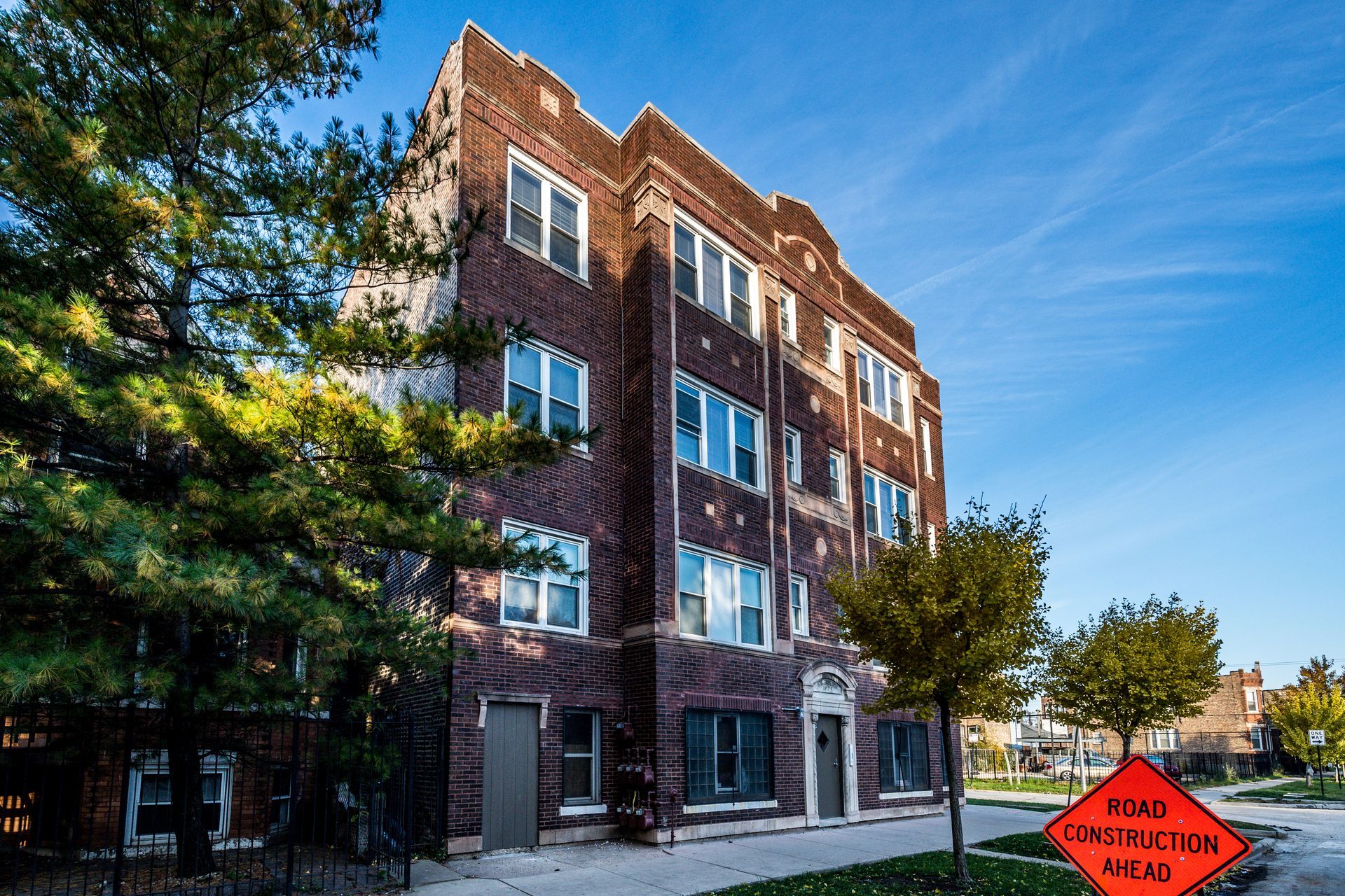 Brick apartment building with blue sky.  Street sign: 