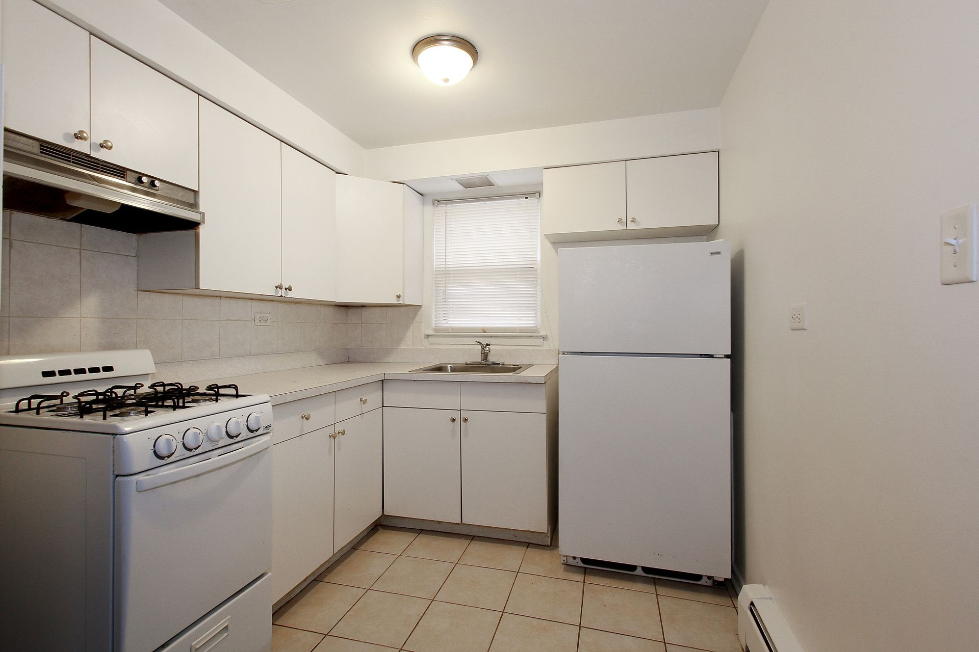 White kitchen with appliances and cabinets.