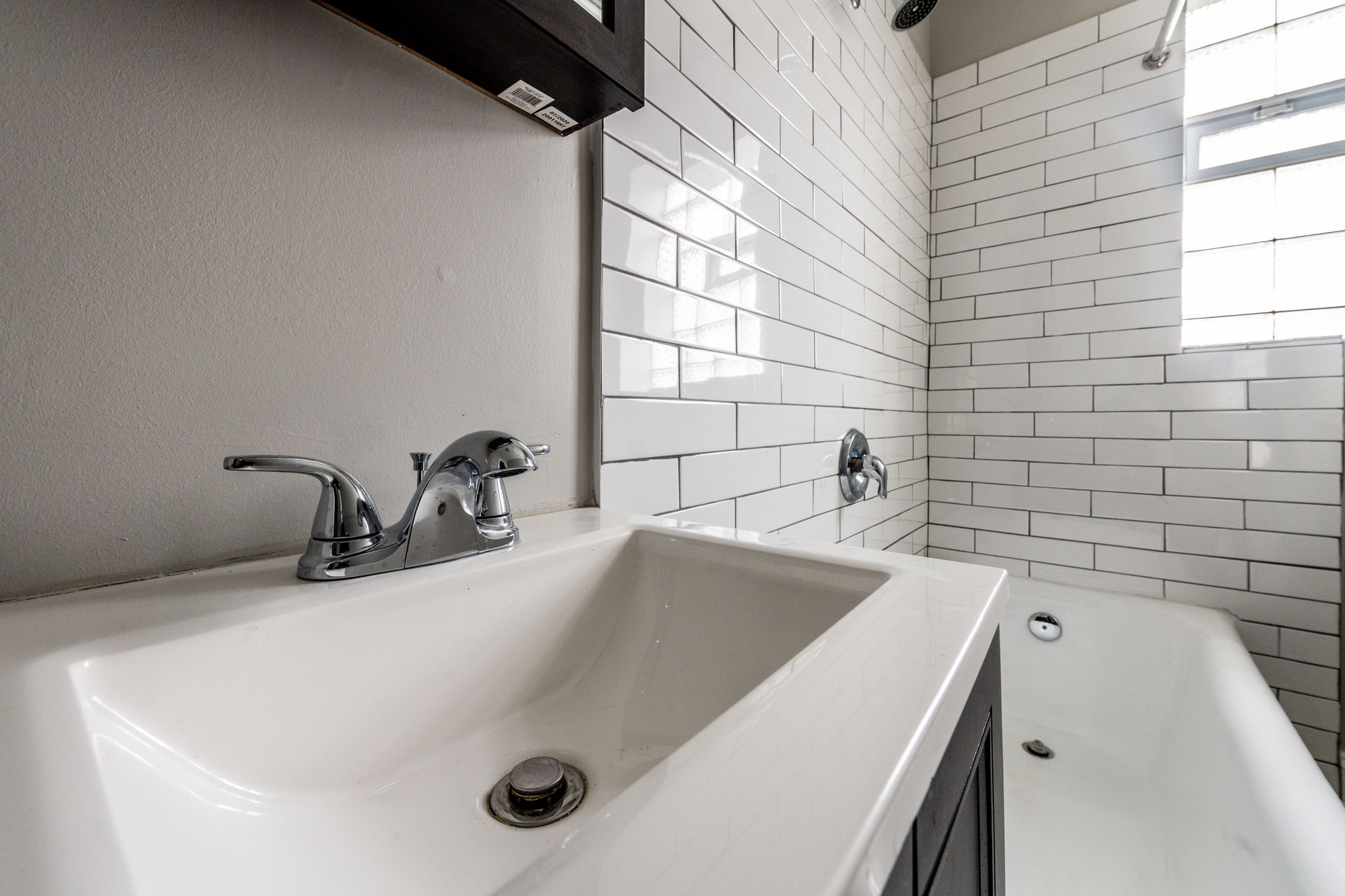 White bathroom with sink, faucet, and tiled shower/tub.