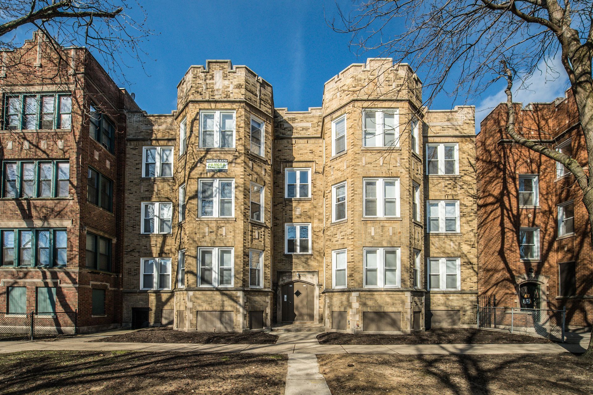 Multi-story brick apartment building on a sunny day.