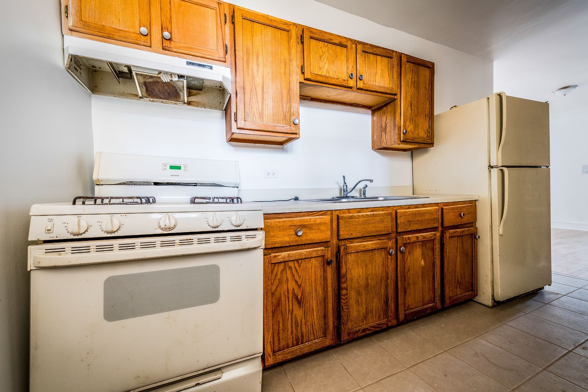 Kitchen with white appliances, wooden cabinets, and a white backsplash.