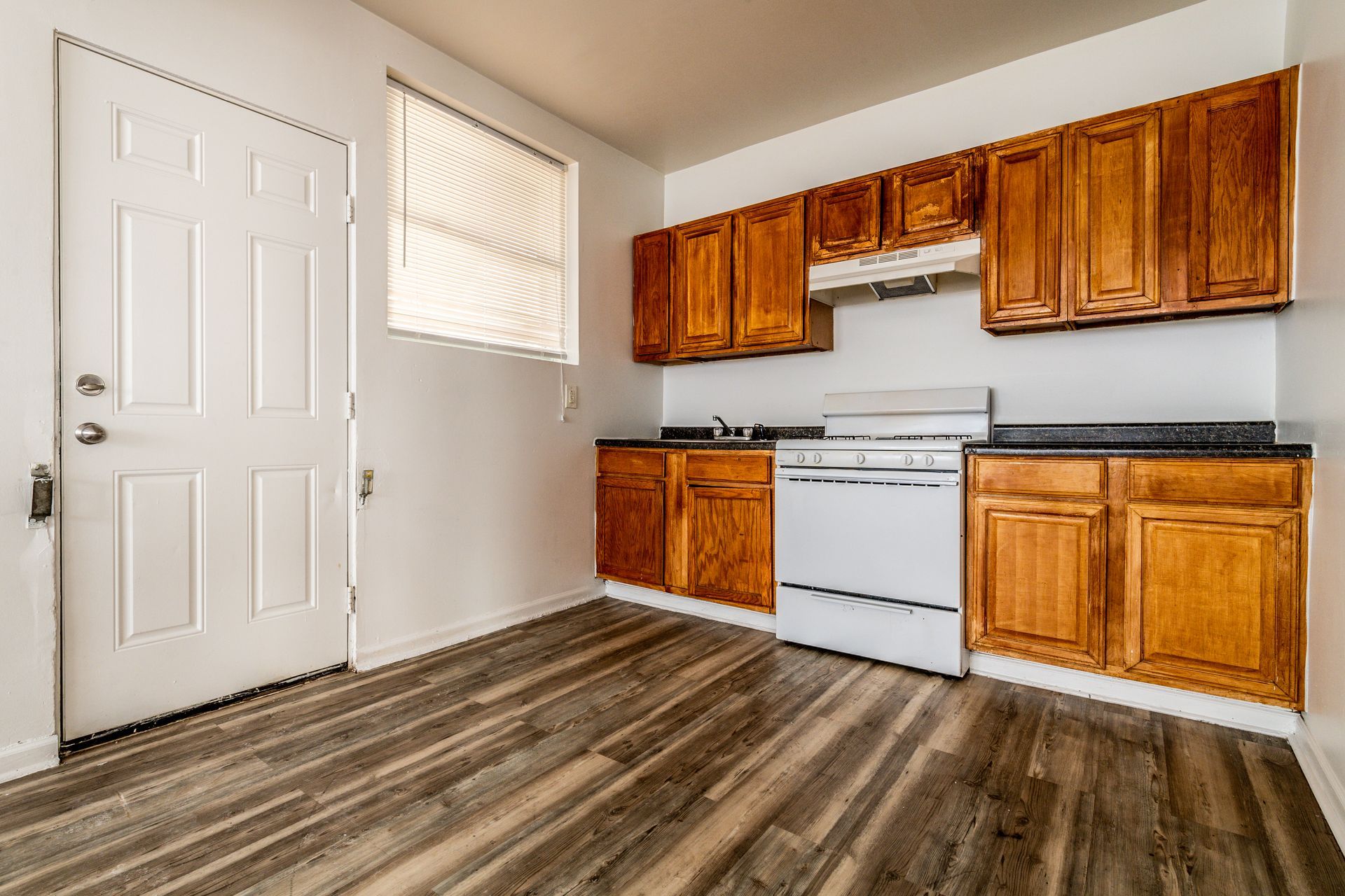 Two-story brick apartment building with white-trimmed windows and a central entrance.