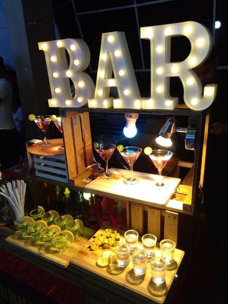 A wooden rustic bar setup at night with a large illuminated 