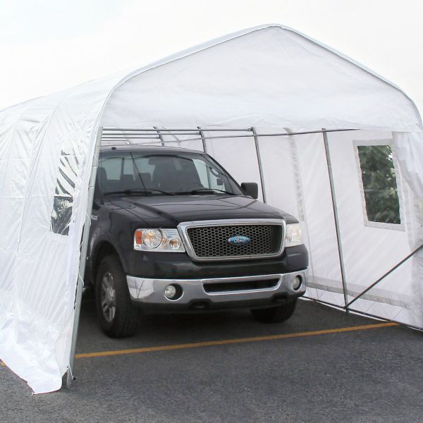 Camionnette Ford noire à l'intérieur d'un abri temporaire blanc. Parking asphalté.