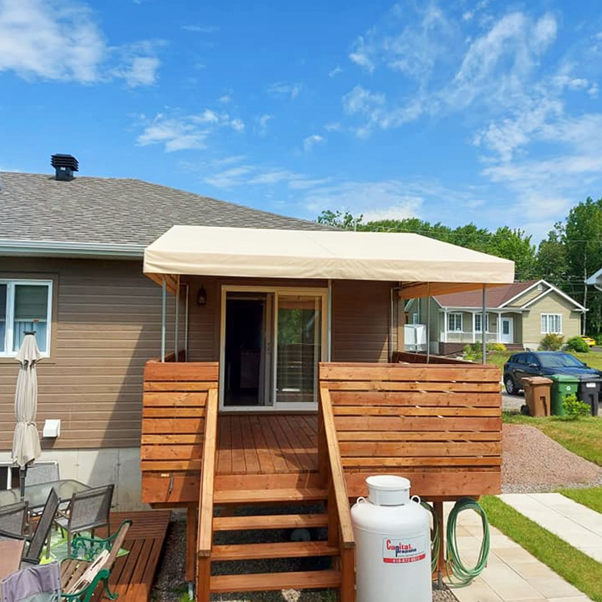 Une maison avec une terrasse en bois et un auvent au-dessus