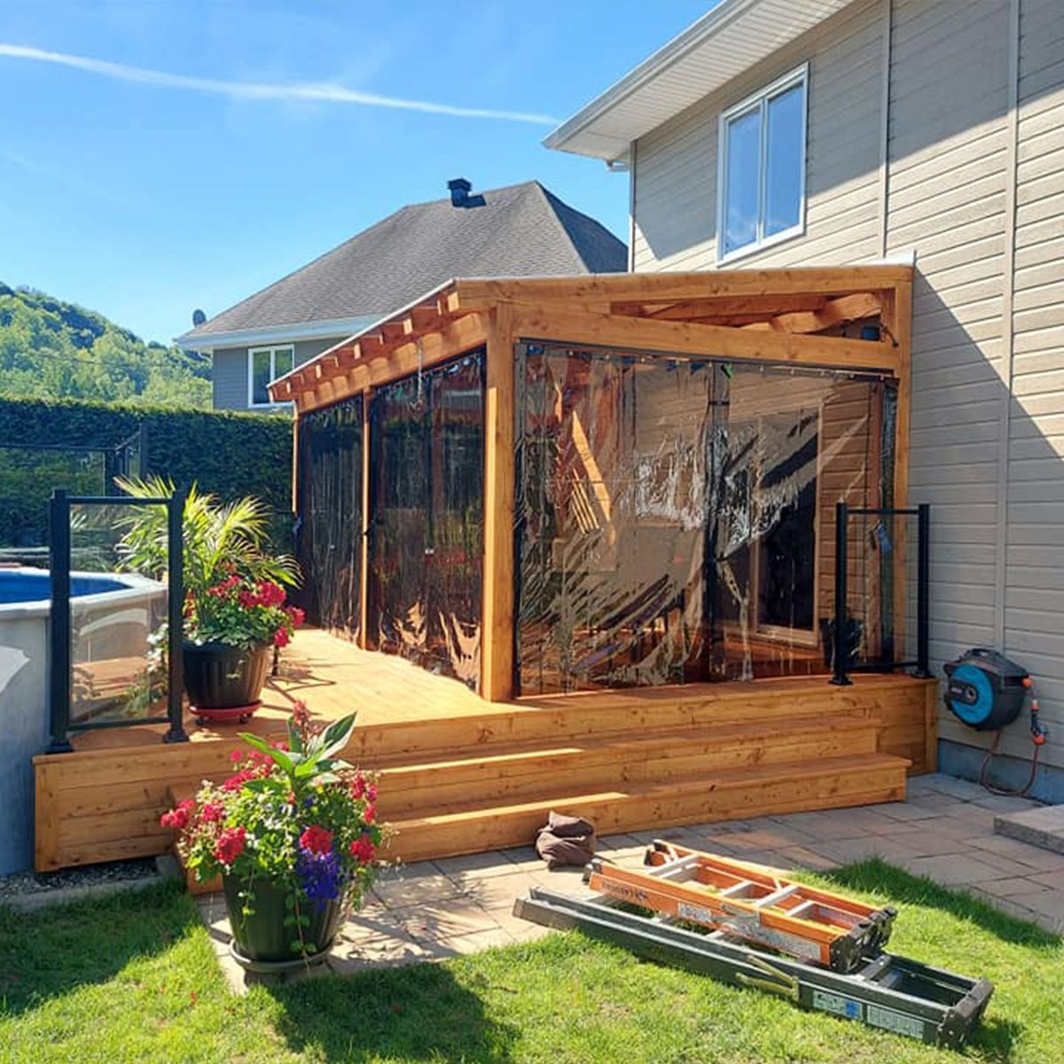 Une maison avec une terrasse en bois et une échelle devant.