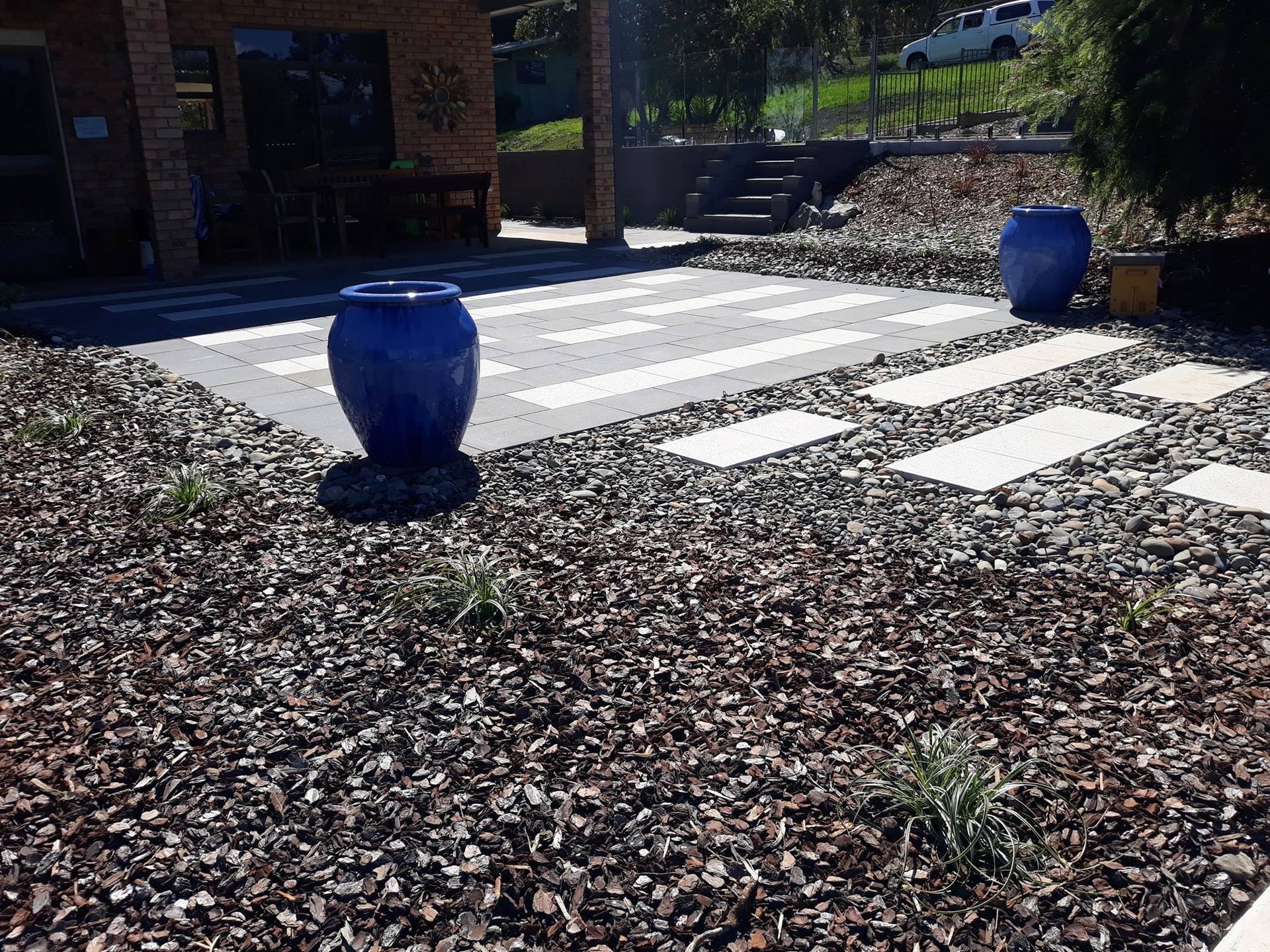 A Blue Pot is Sitting on Top of a Pile of Gravel — Seascapes Landscape Construction in Kendall, NSW