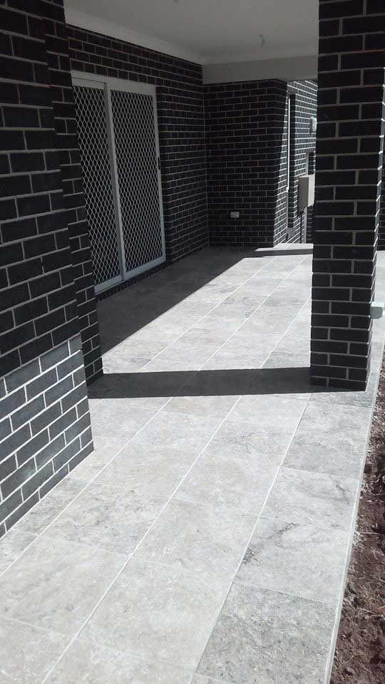 A Brick Building With a Patio and a Sliding Glass Door — Seascapes Landscape Construction in Kendall, NSW