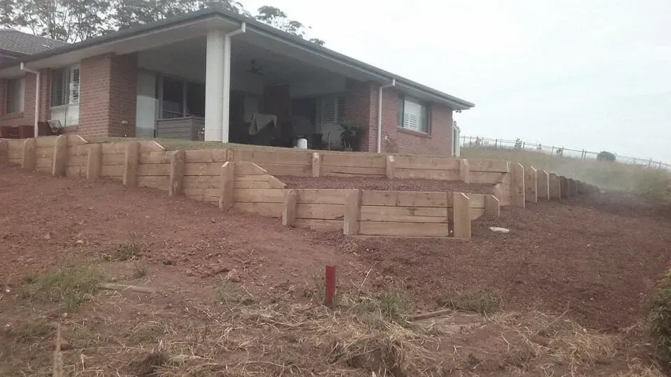 A Stone Border in a Garden With a Palm Tree — Seascapes Landscape Construction in Kendall, NSW