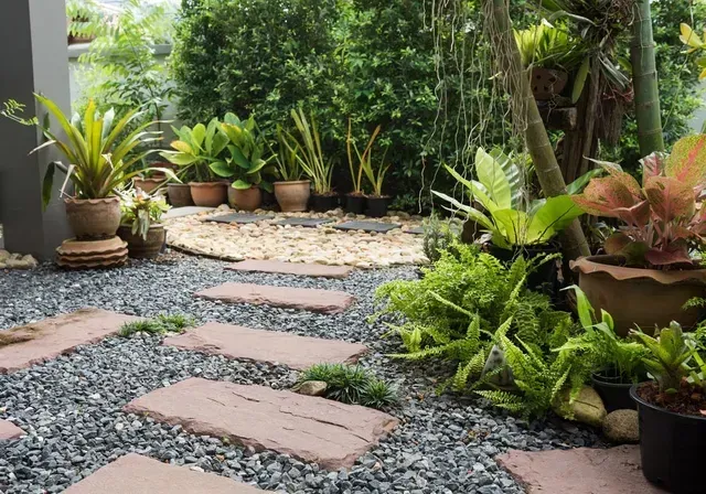 A Garden With Lots of Potted Plants and Stepping Stones — Seascapes Landscape Construction in Wauchope, NSW
