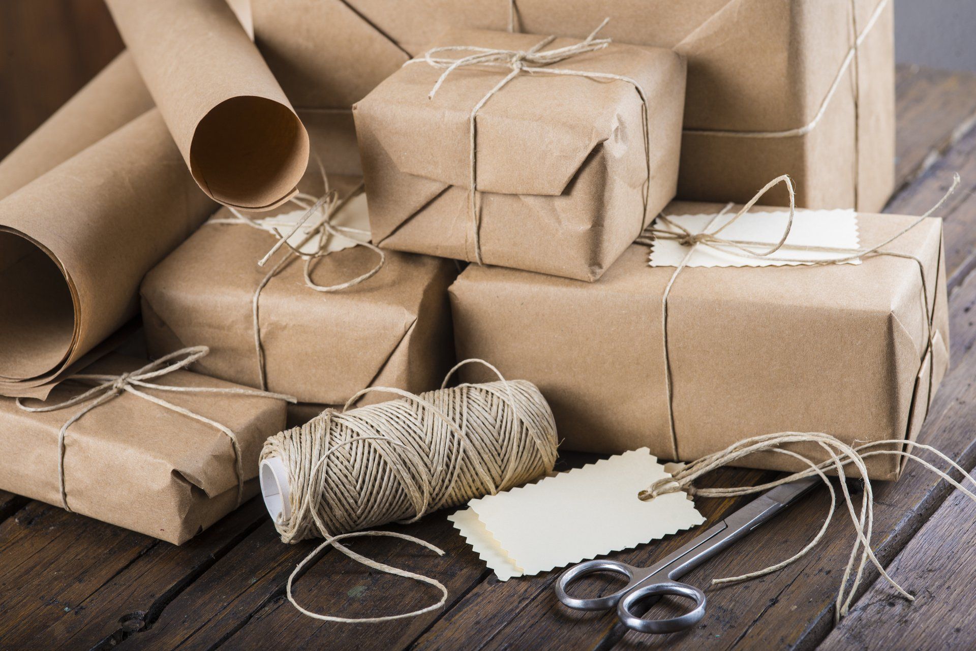 A wooden table topped with boxes wrapped in brown paper