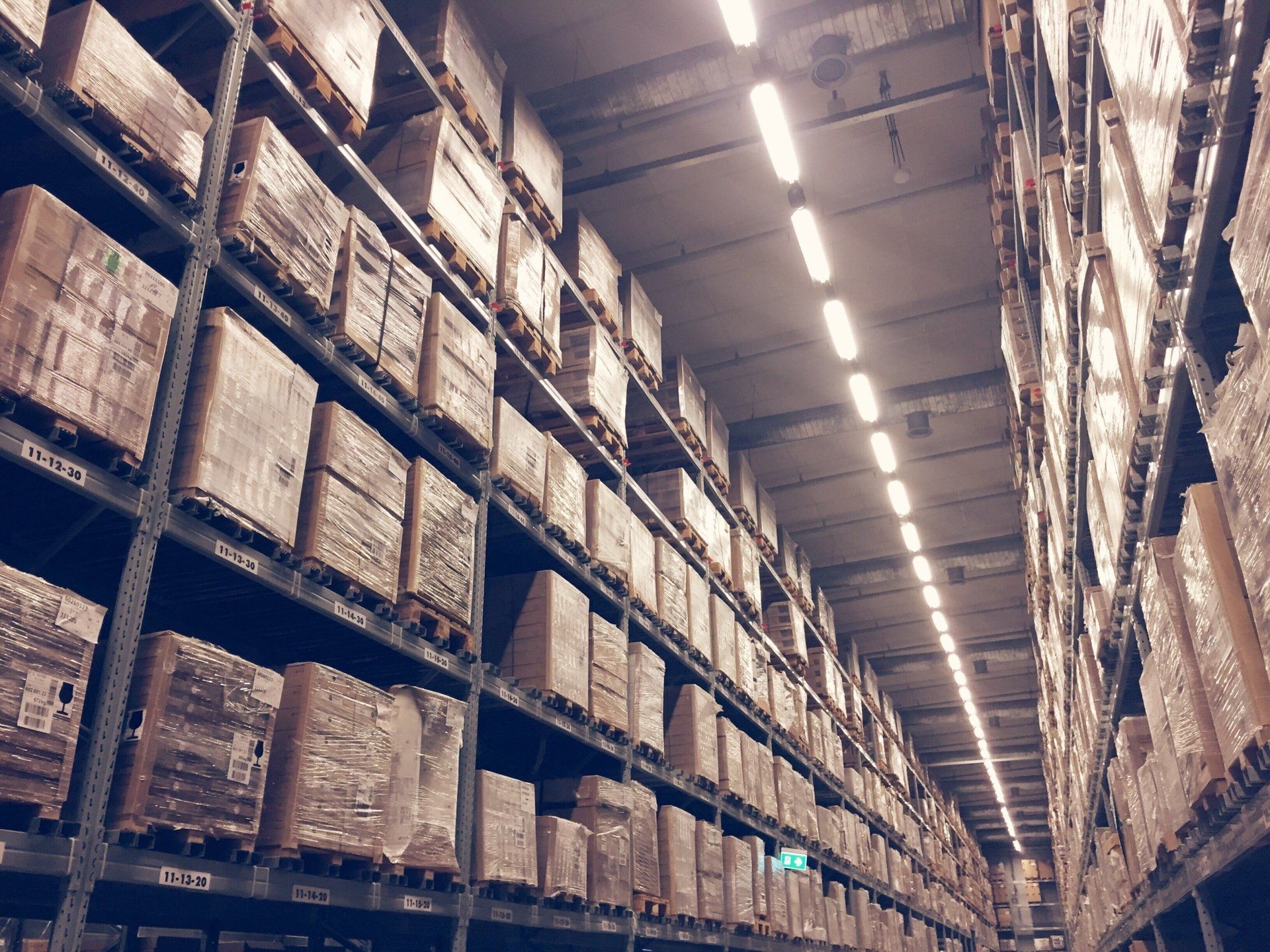 A large warehouse filled with lots of boxes on shelves.