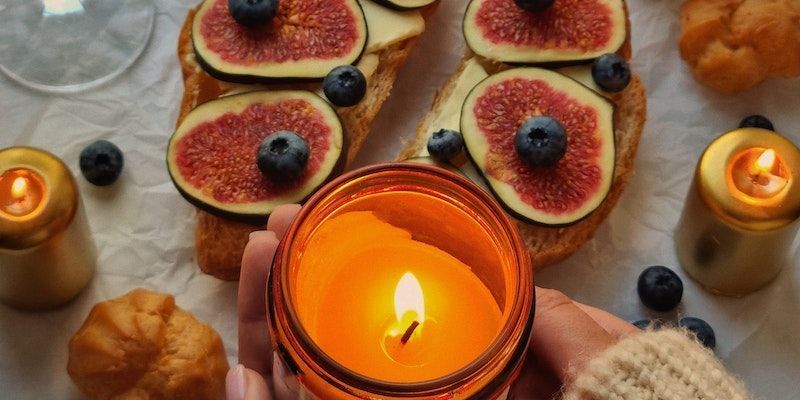 Candlelit dessert spread with fig tartlets and blueberries on a rustic table