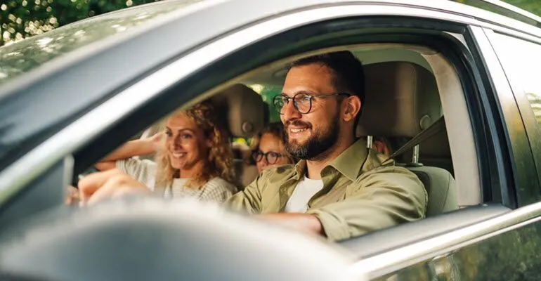 A man is driving a car with a family in the back seat | Autohaus Service & Sales