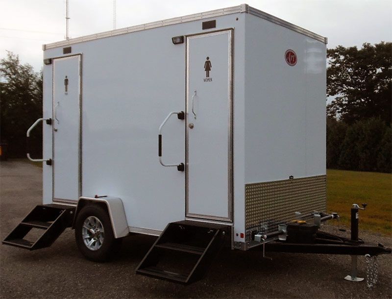 A white trailer with a toilet on the side
