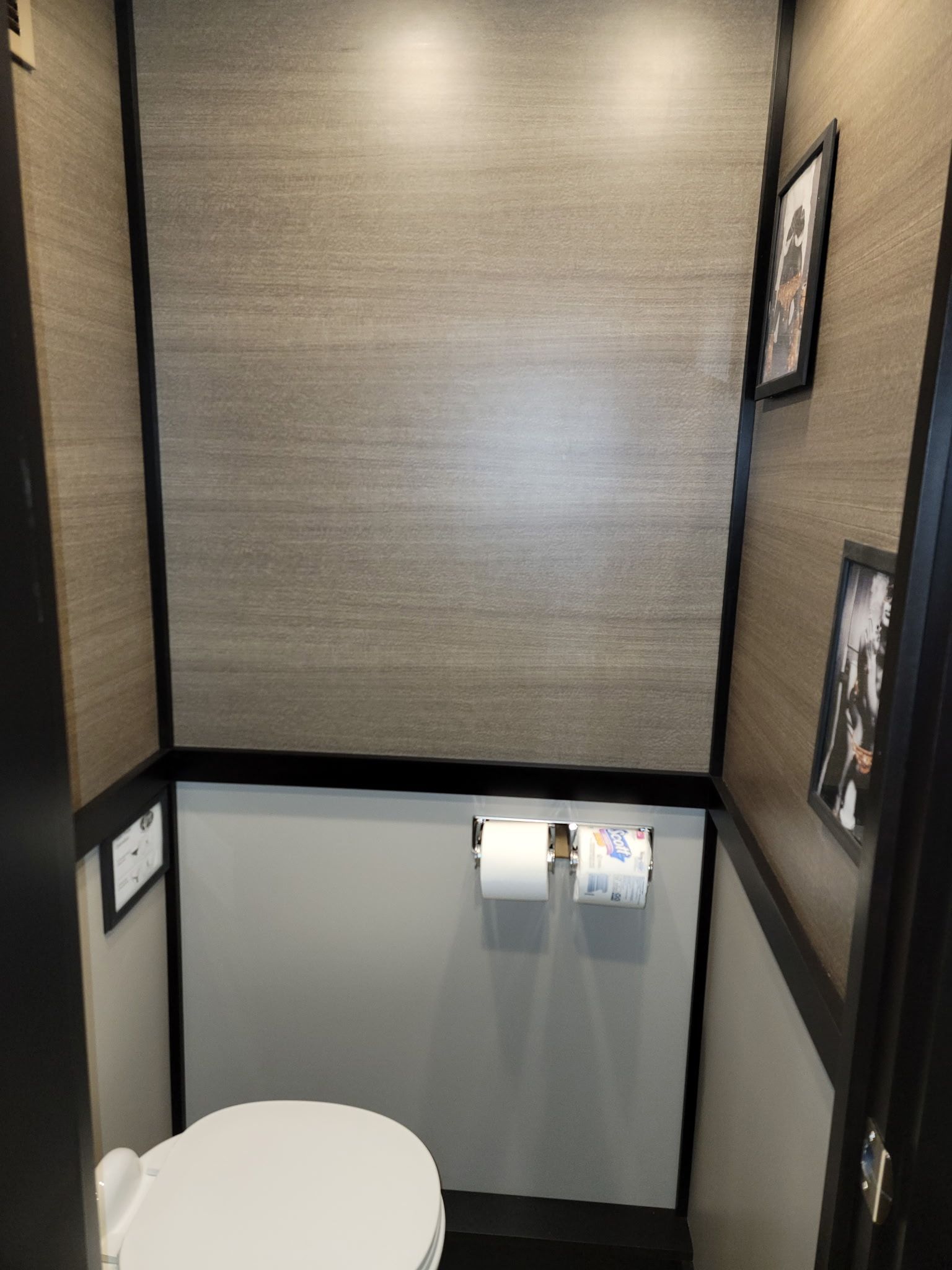 A bathroom with a toilet and two rolls of toilet paper