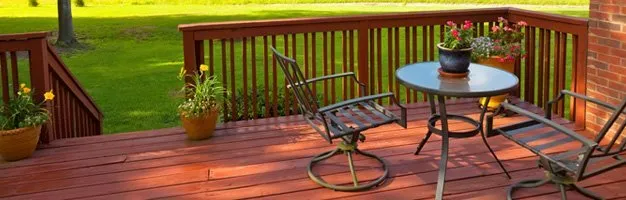 A wooden deck with a table and chairs on it.