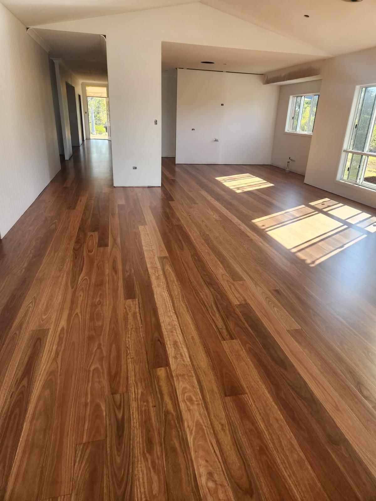 A Living Room with Hardwood Floors and White Walls — Finish It Floor Sanding in Bundaberg, QLD