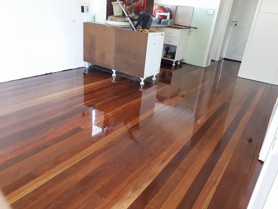 A Wooden Floor in A Room with A Counter in The Background — Finish It Floor Sanding in Bucca, QLD