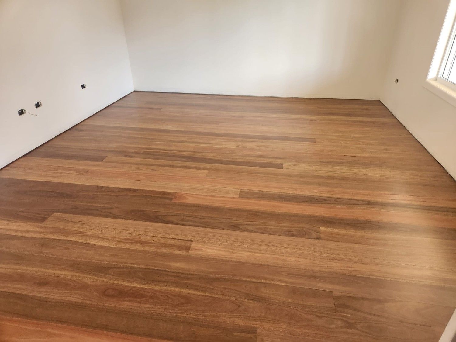 A Room with A Wooden Floor and White Walls — Finish It Floor Sanding in Bucca, QLD