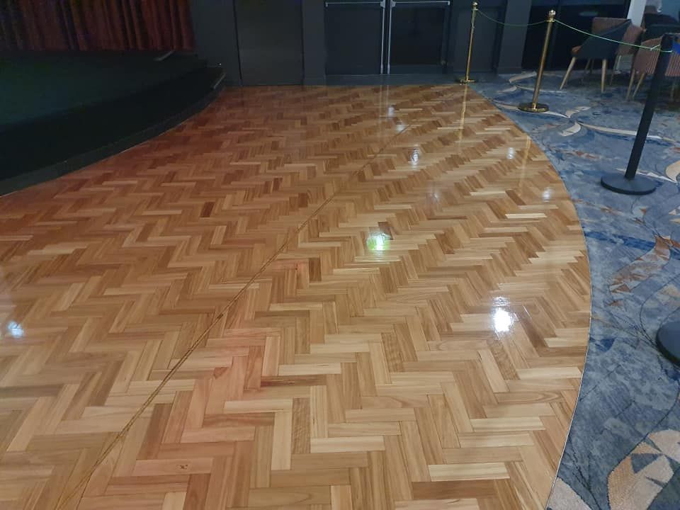 A Wooden Floor with A Herringbone Pattern in A Room — Finish It Floor Sanding in Bucca, QLD