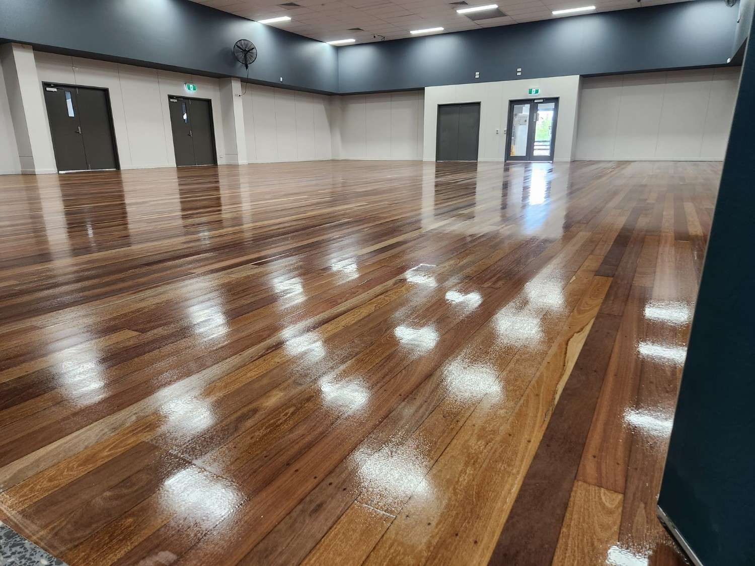 A Large Empty Room with A Wooden Floor — Finish It Floor Sanding in Gayndah, QLD