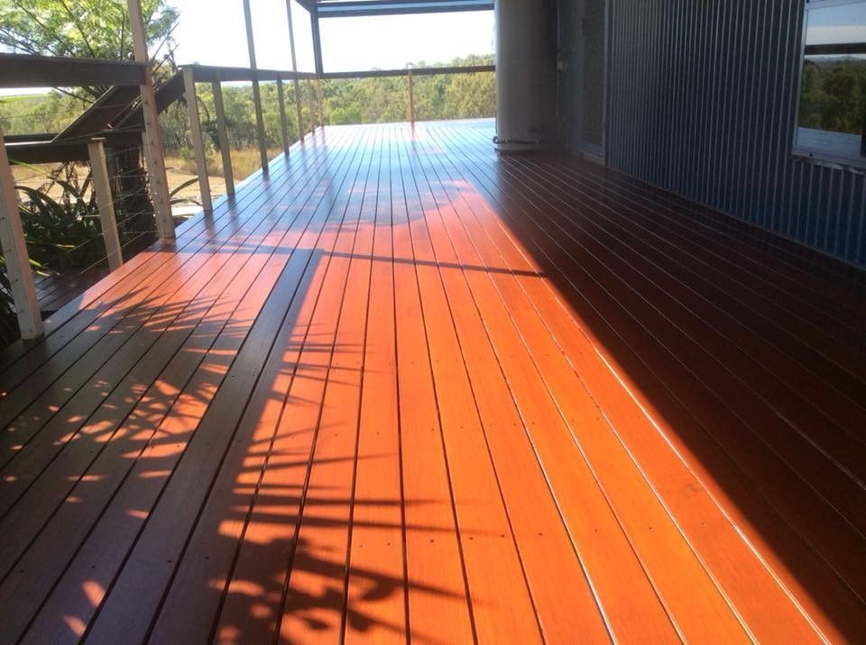 A Wooden Deck with The Sun Shining on It — Finish It Floor Sanding in Gladstone, QLD