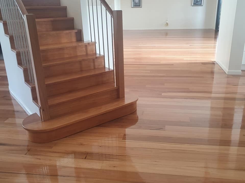 A Wooden Staircase in A Living Room with A Wooden Floor — Finish It Floor Sanding in Bucca, QLD